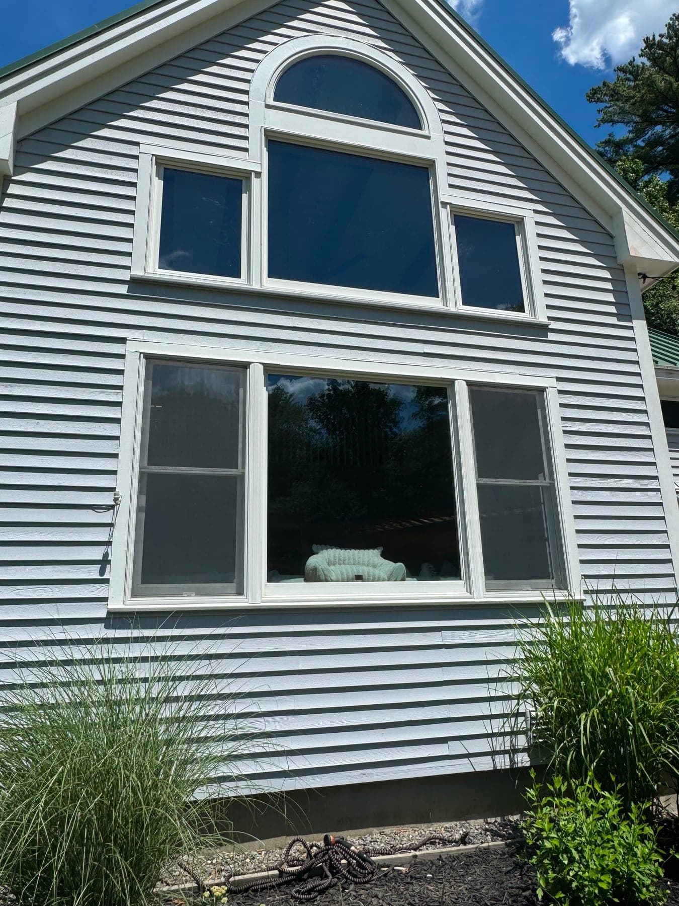 A triple window with new white casings on a clapboard wall