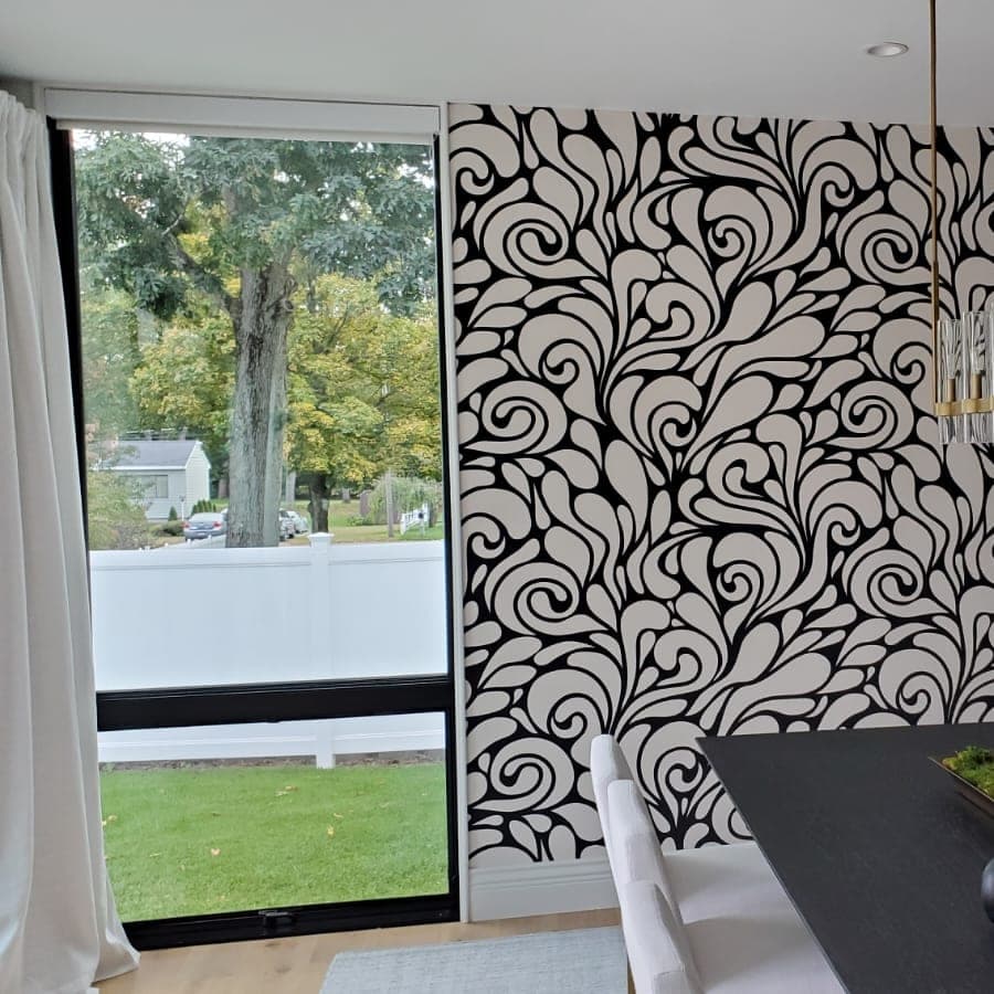 Dining room with a black-and-white scroll wallpaper, a dark hutch and a long table